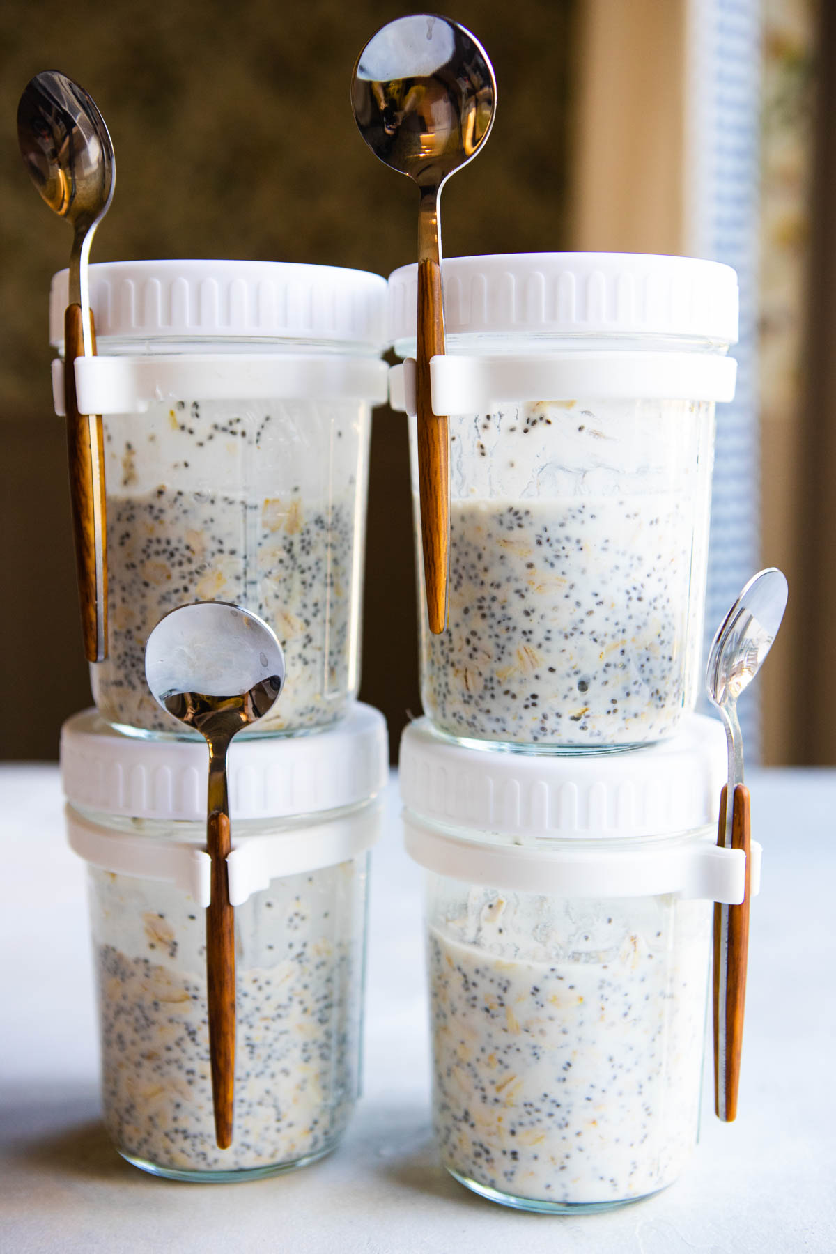 4 mason jars filled with kefir overnight oats sealed with spoons