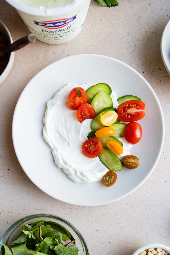 Greek yogurt with sliced cucumbers and tomatoes on top