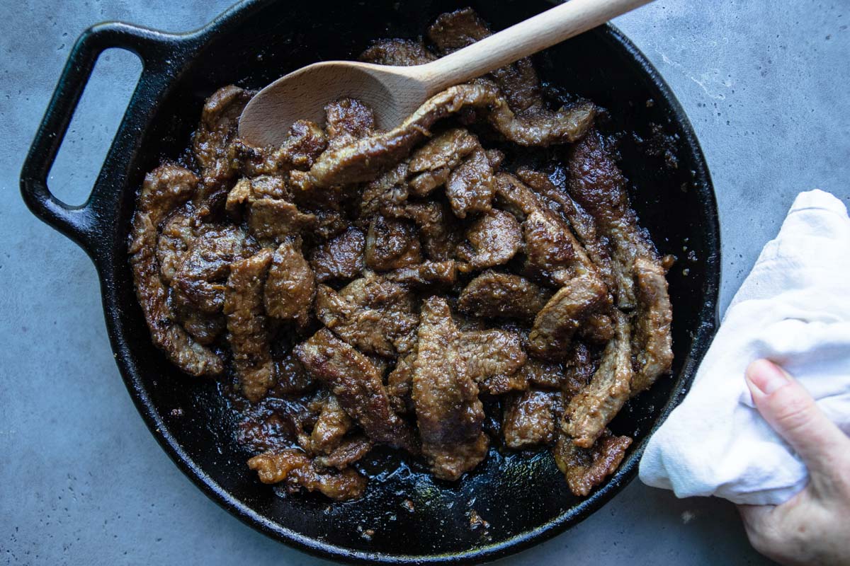 cooked flank steak in a cast iron skillet