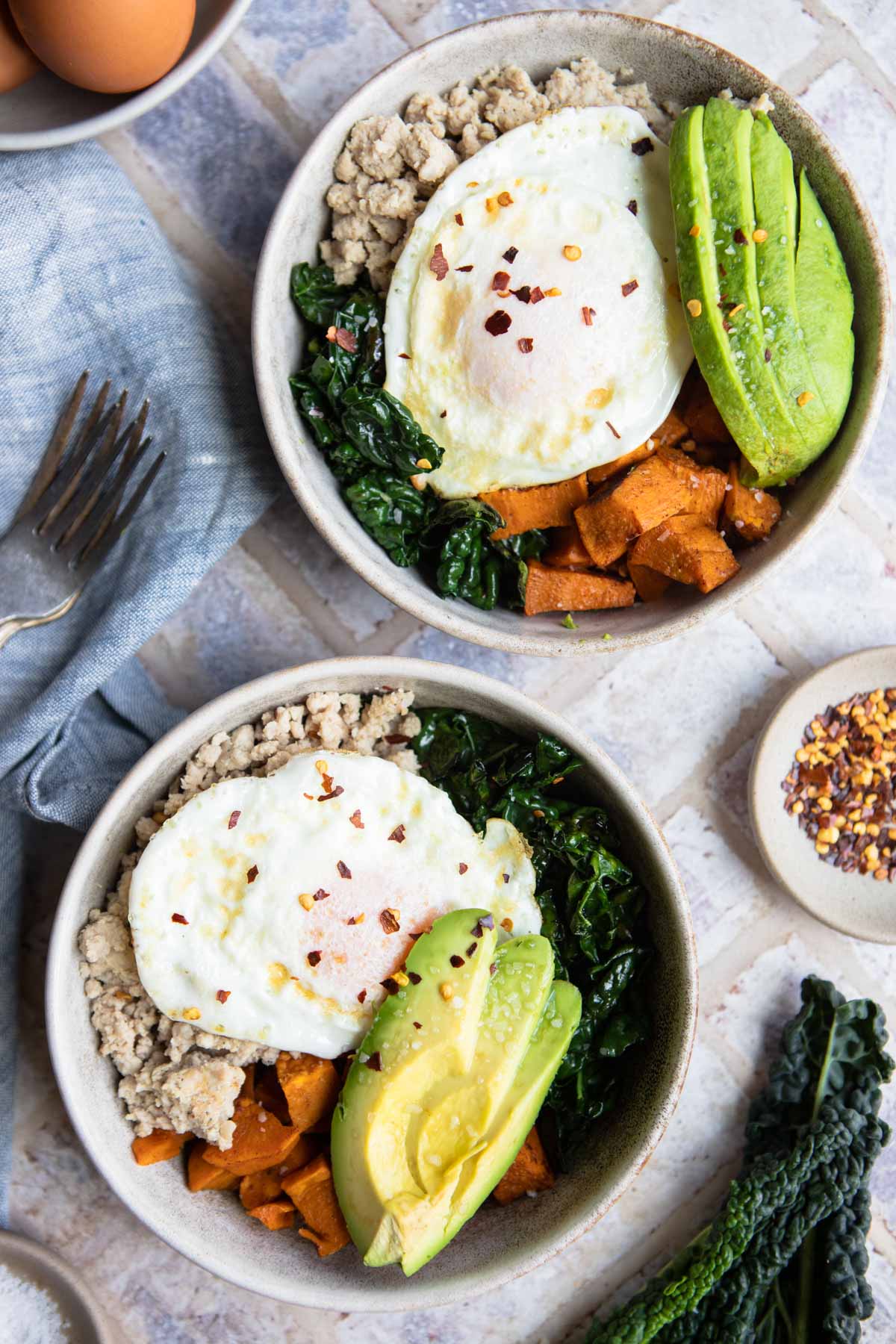 sweet potato breakfast bowls in beige bowls on a brick surface 