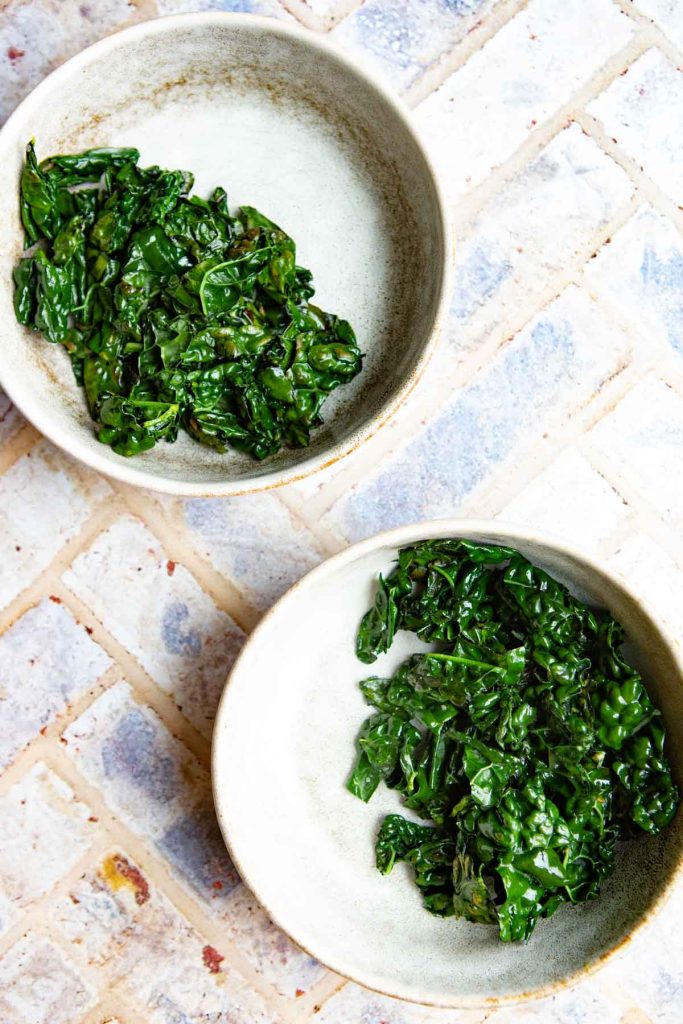 cooked kale placed in 2 small bowls
