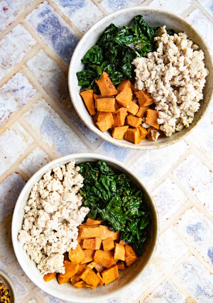 cooked kale, cooked ground turkey and roasted sweet potatoes in 2 round beige bowls