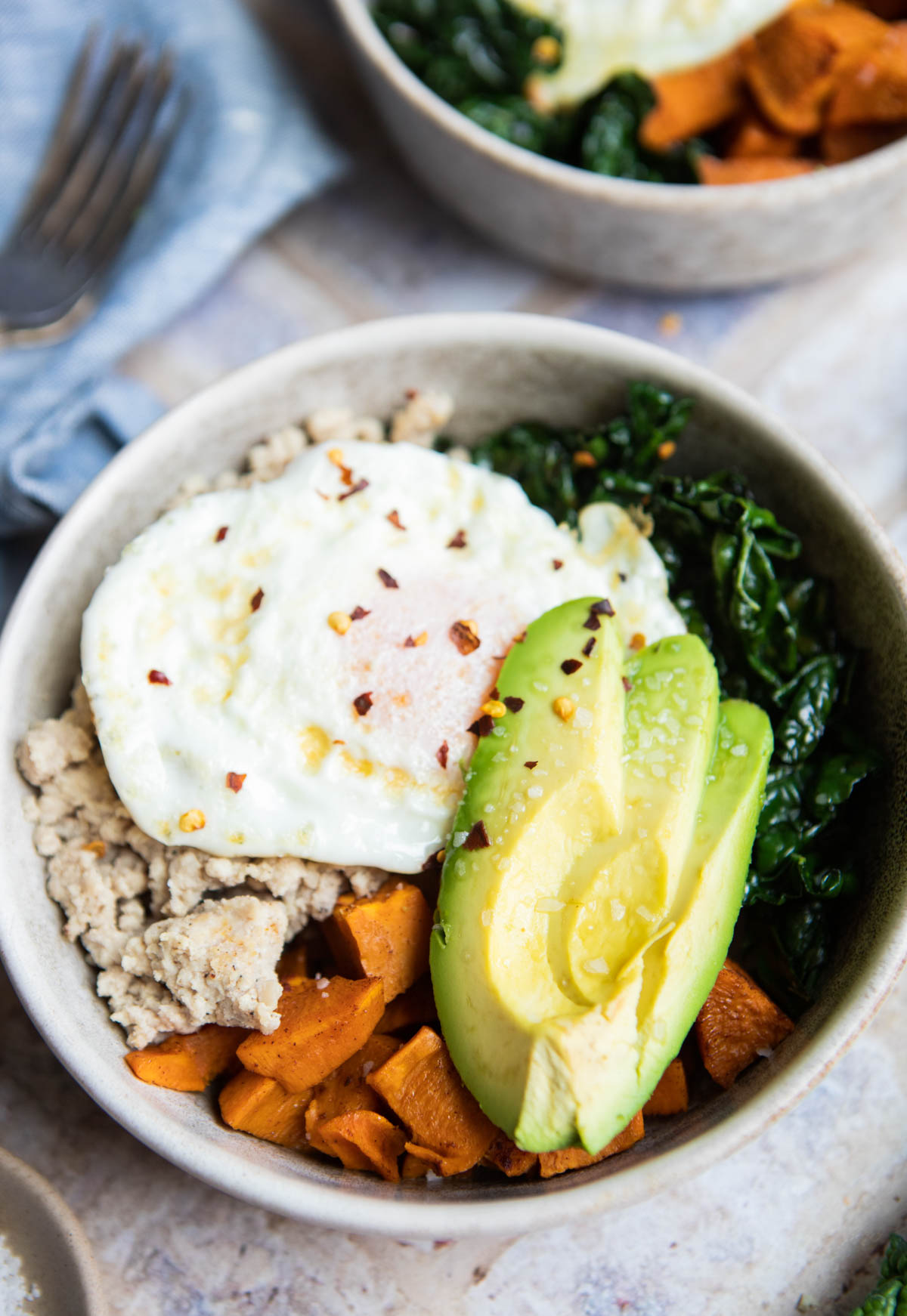 an over easy egg topped on a sweet potato breakfast bowl
