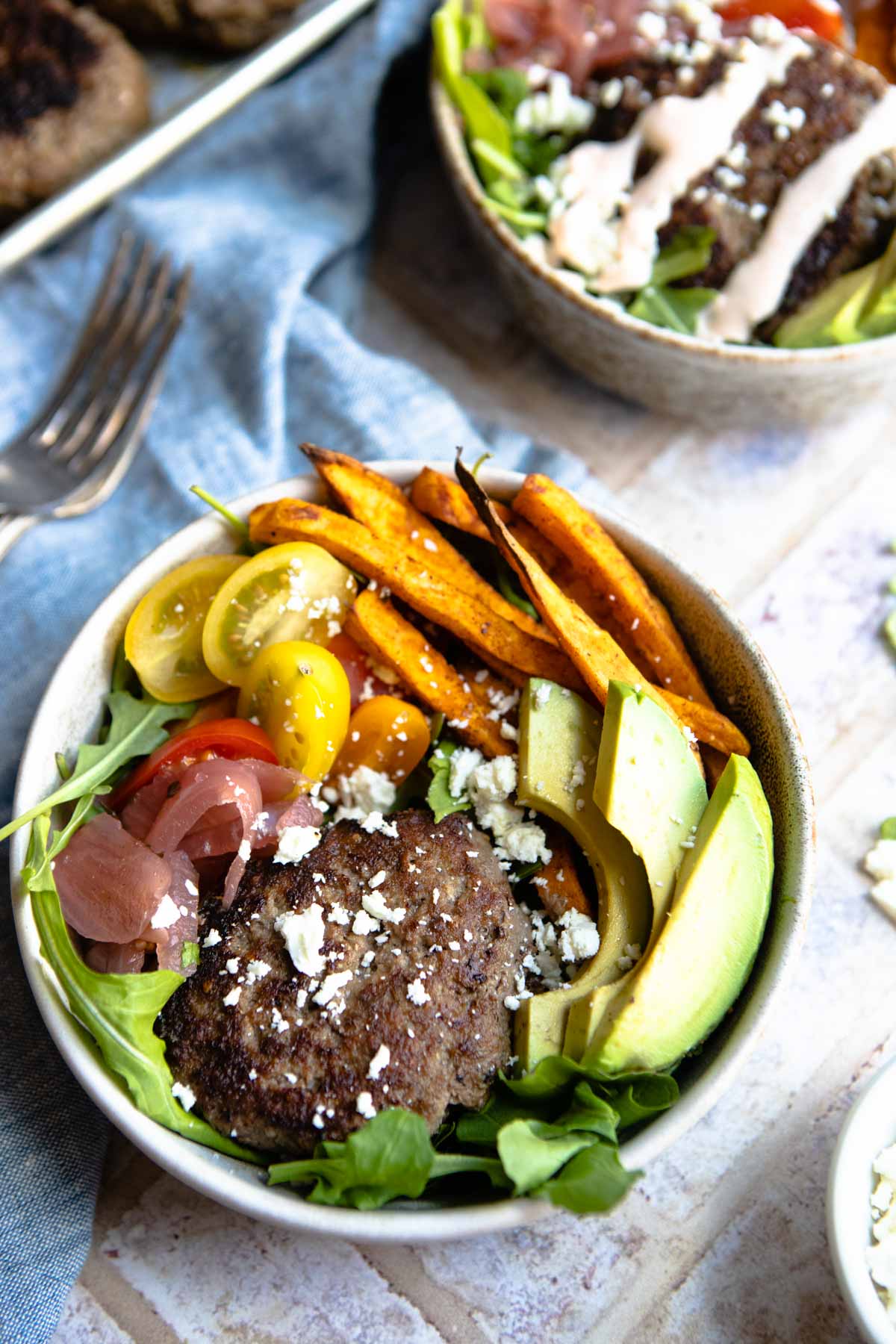 burger bowls with sweet potatoes and garnished with feta cheese and special burger sauce