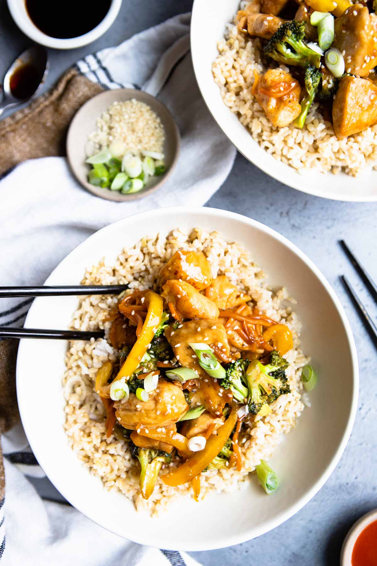 chicken teriyaki bowls filled in a cream colored bowl and a black pair of chopsticks