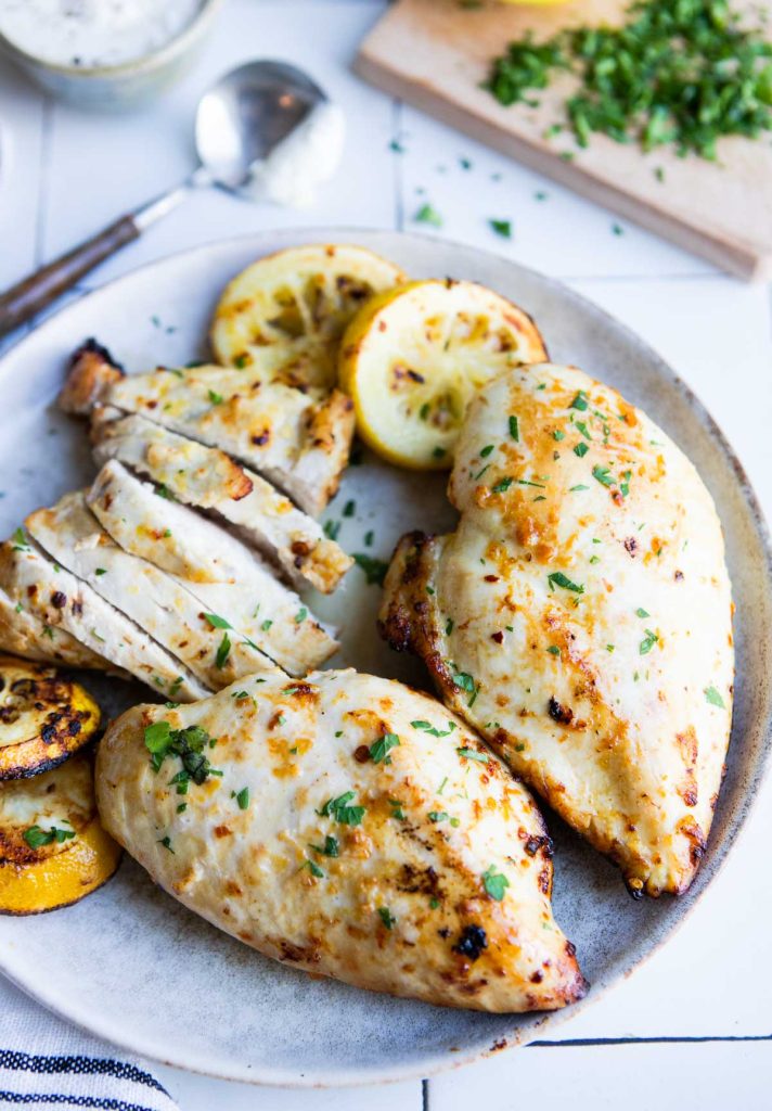 plated air fryer lemon chicken breasts garnished with lemon slices