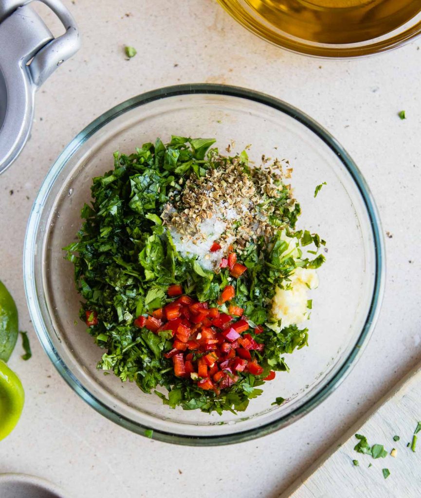 chopped herbs and garlic and red pepper tossed in a small glass bowl