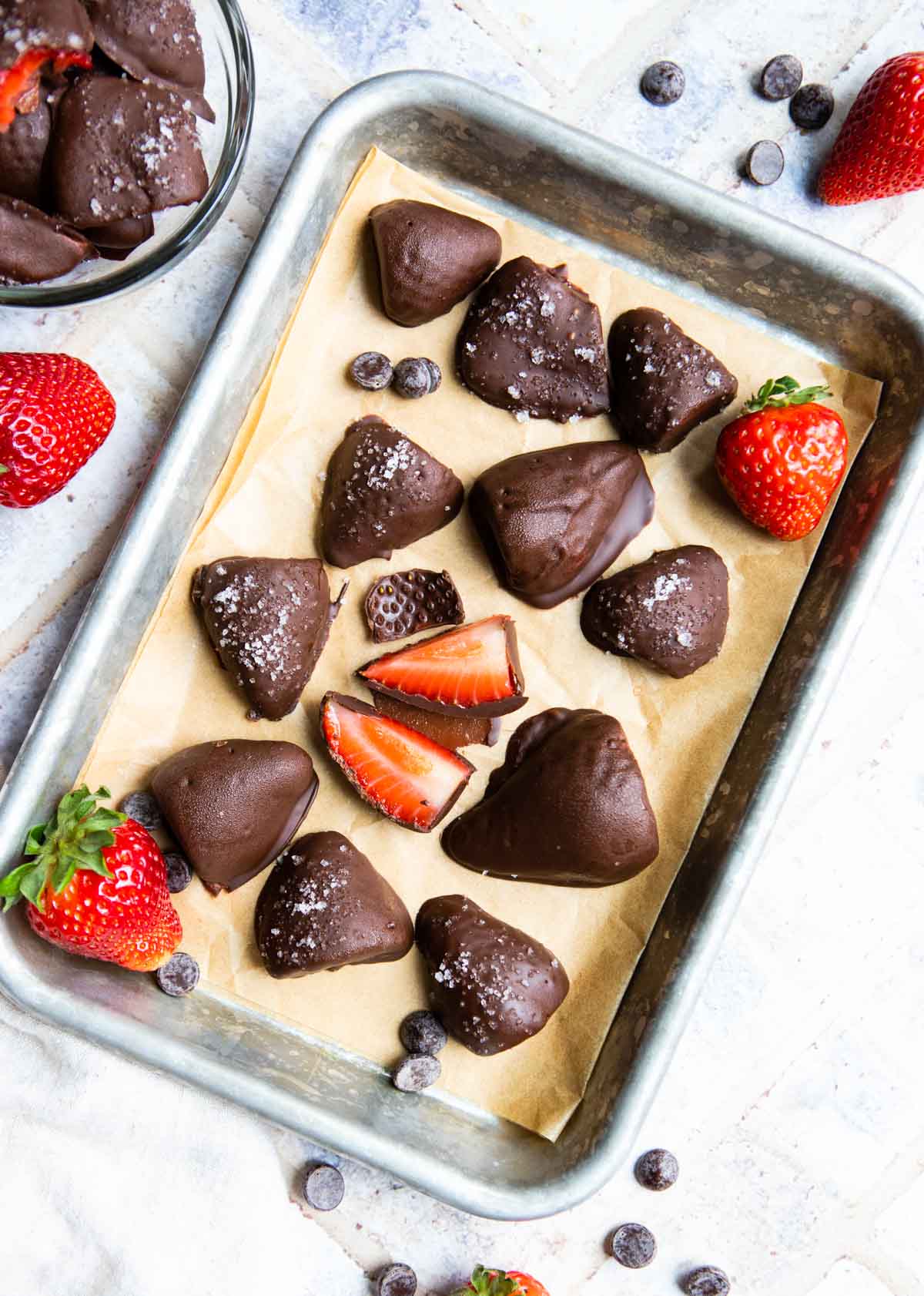 frozen chocolate dipped strawberries on a parchment lined baking tray
