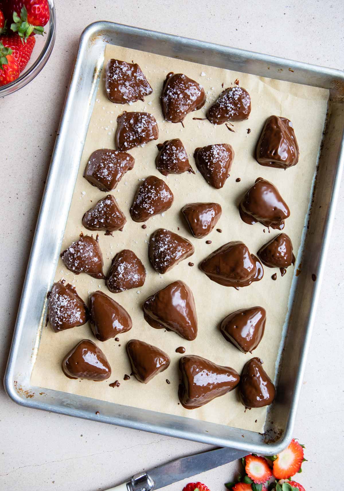 chocolate dipped strawberries set on a baking sheet ready to go in the freezer