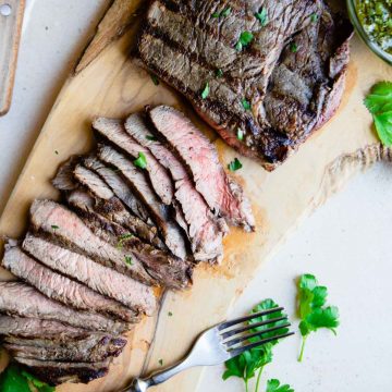 grilled top sirloin steak sliced thin and laid out on a cutting board