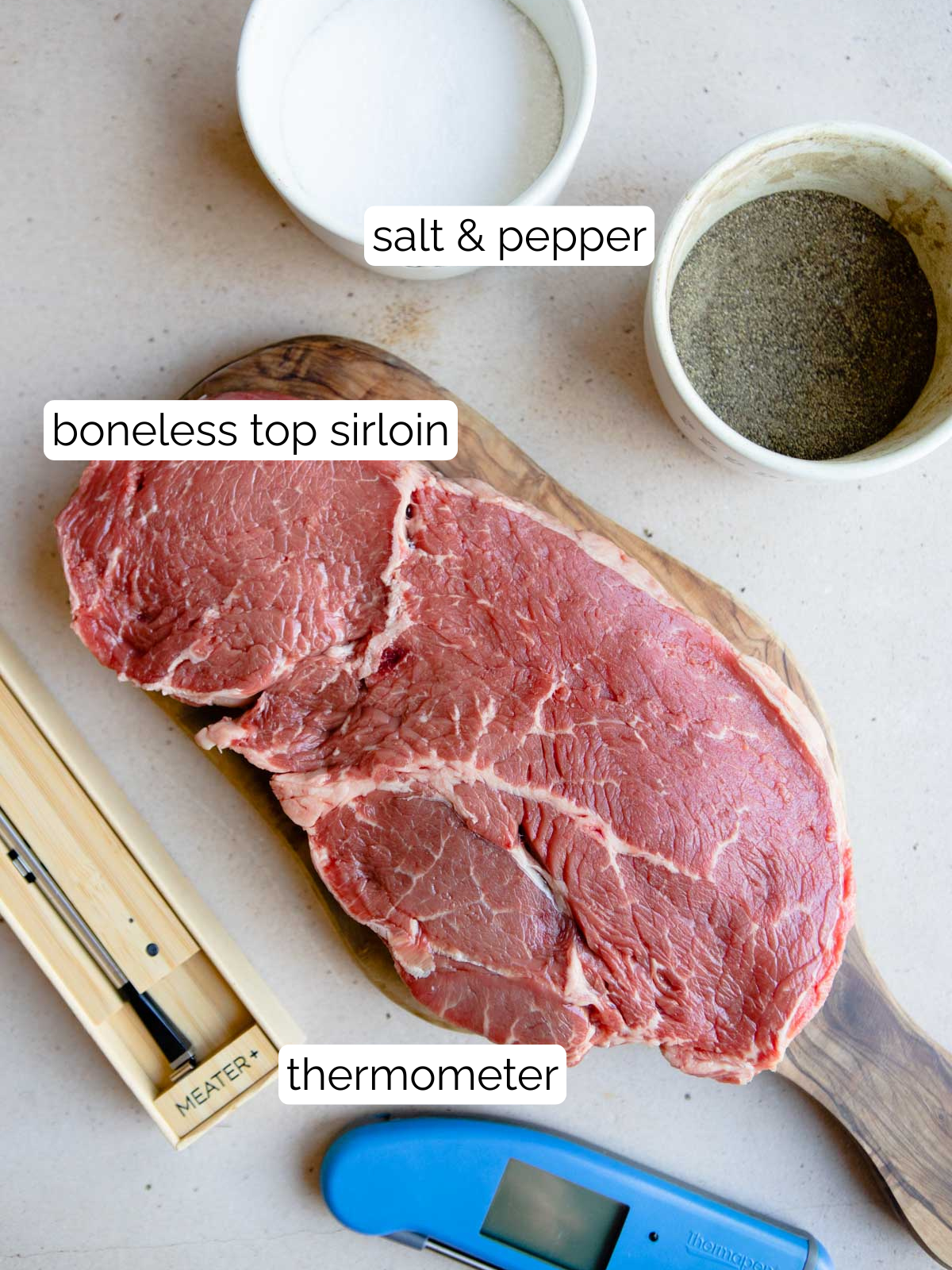 raw top sirloin steak and salt and pepper with a thermometer 