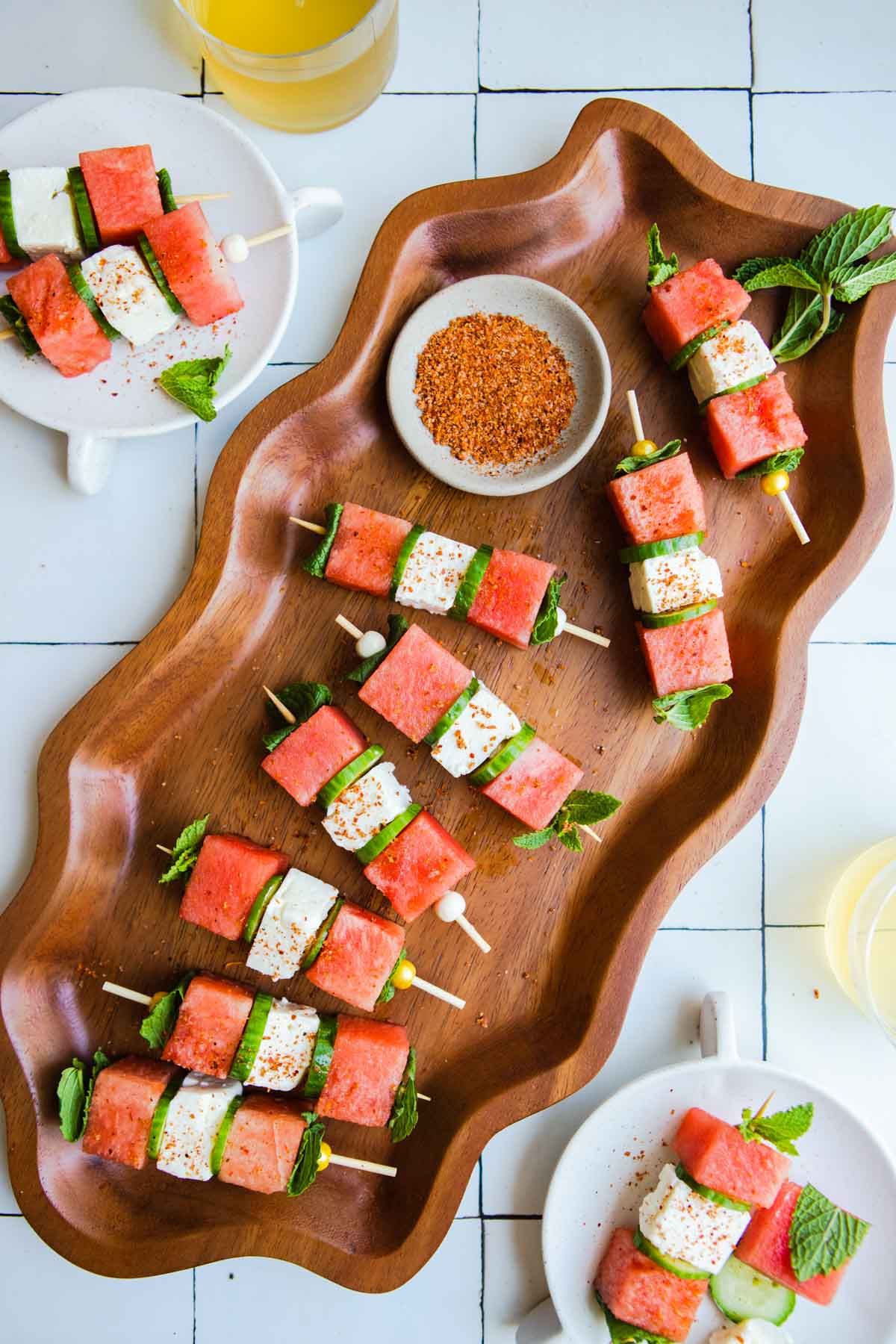 wavy platter with watermelon feta skewers placed on top and sprinkled with Tajin seasoning 