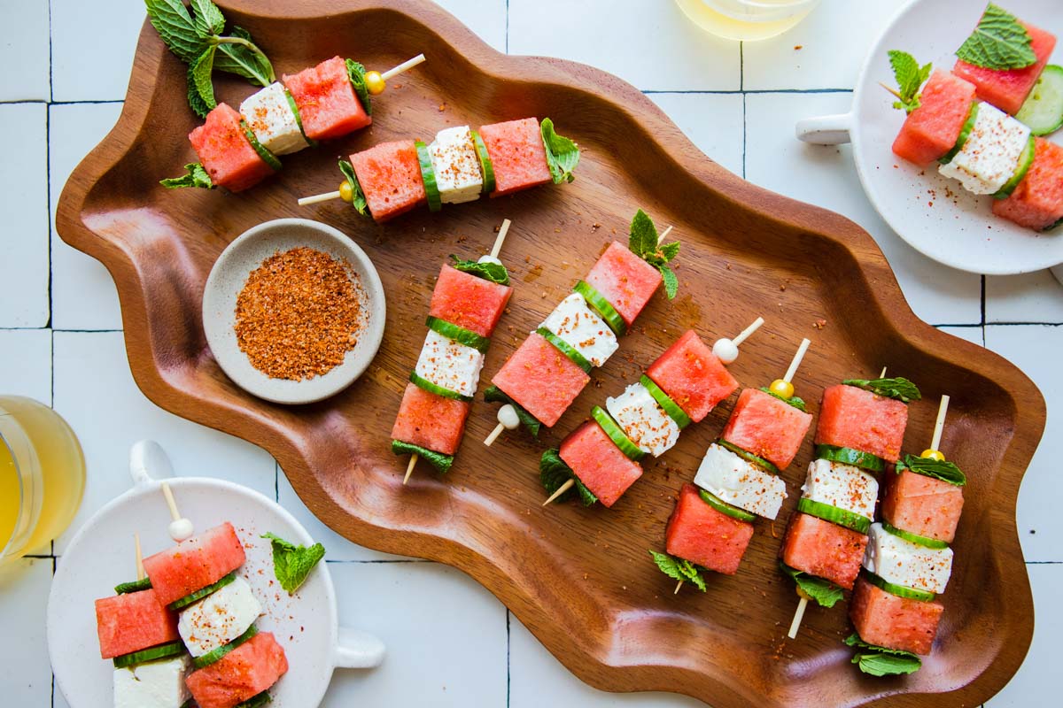 wavy wood platter filled with a watermelon appetizer and sprinkled with tajin
