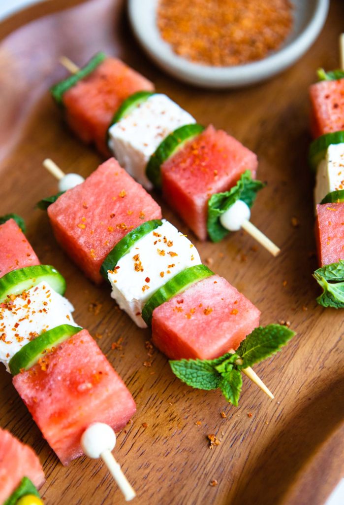 watermelon feta mint skewers on a wood platter with tajin sprinkled on top