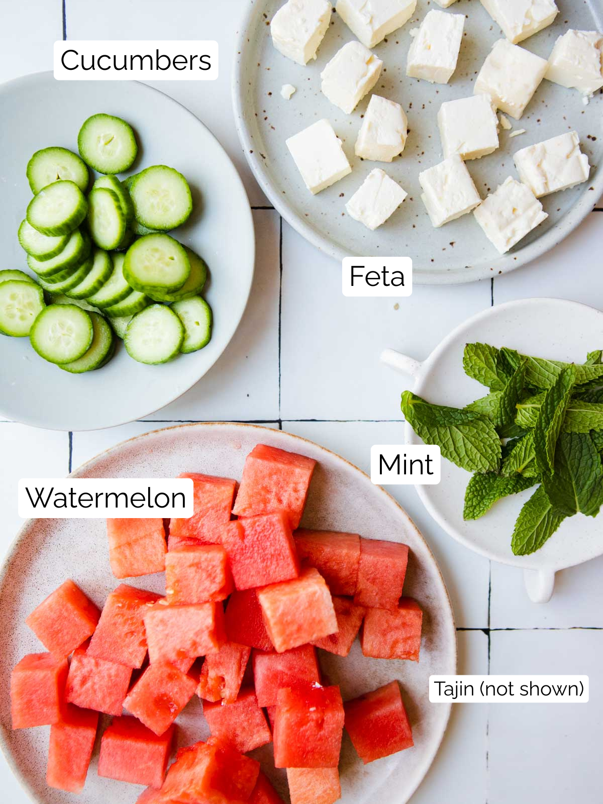 ingredients to make watermelon, feta, cucumber and mint appetizers on white plates