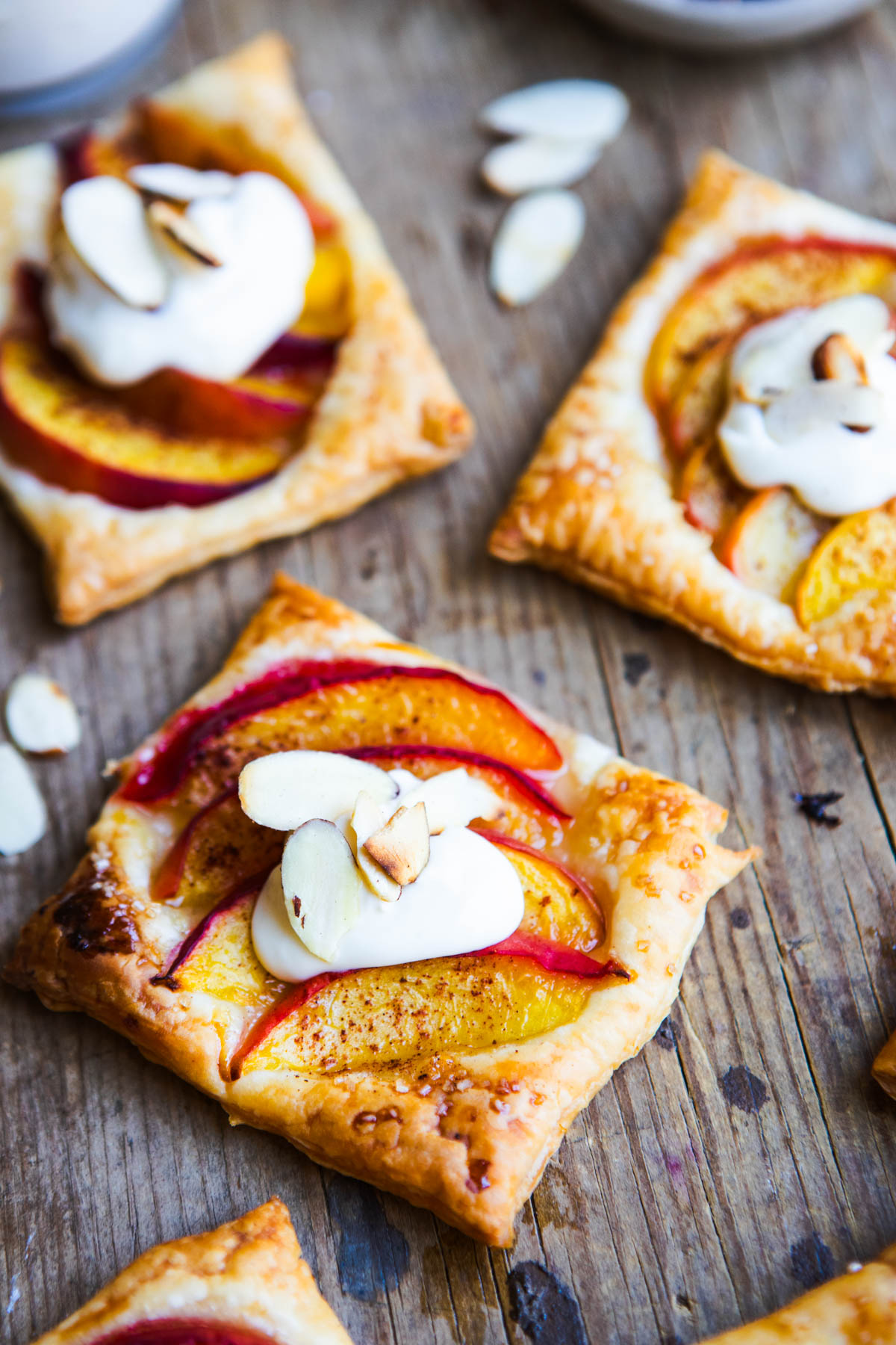 peach tarts topped with cream cheese topping and slivered almonds