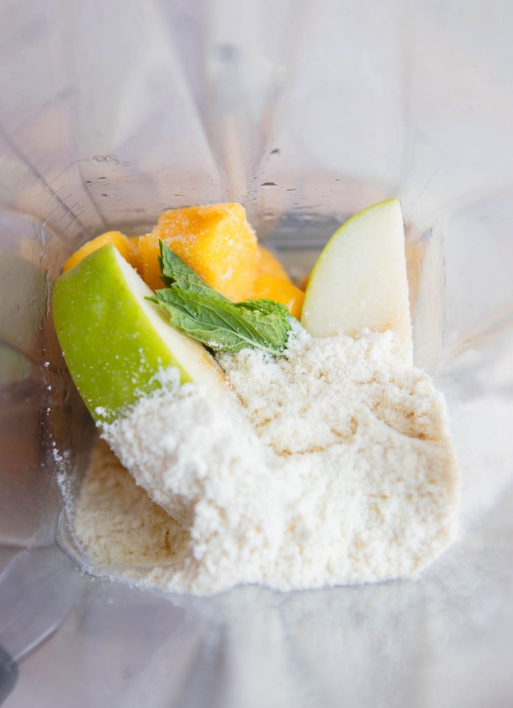 mango protein smoothie ingredients added to a blender
