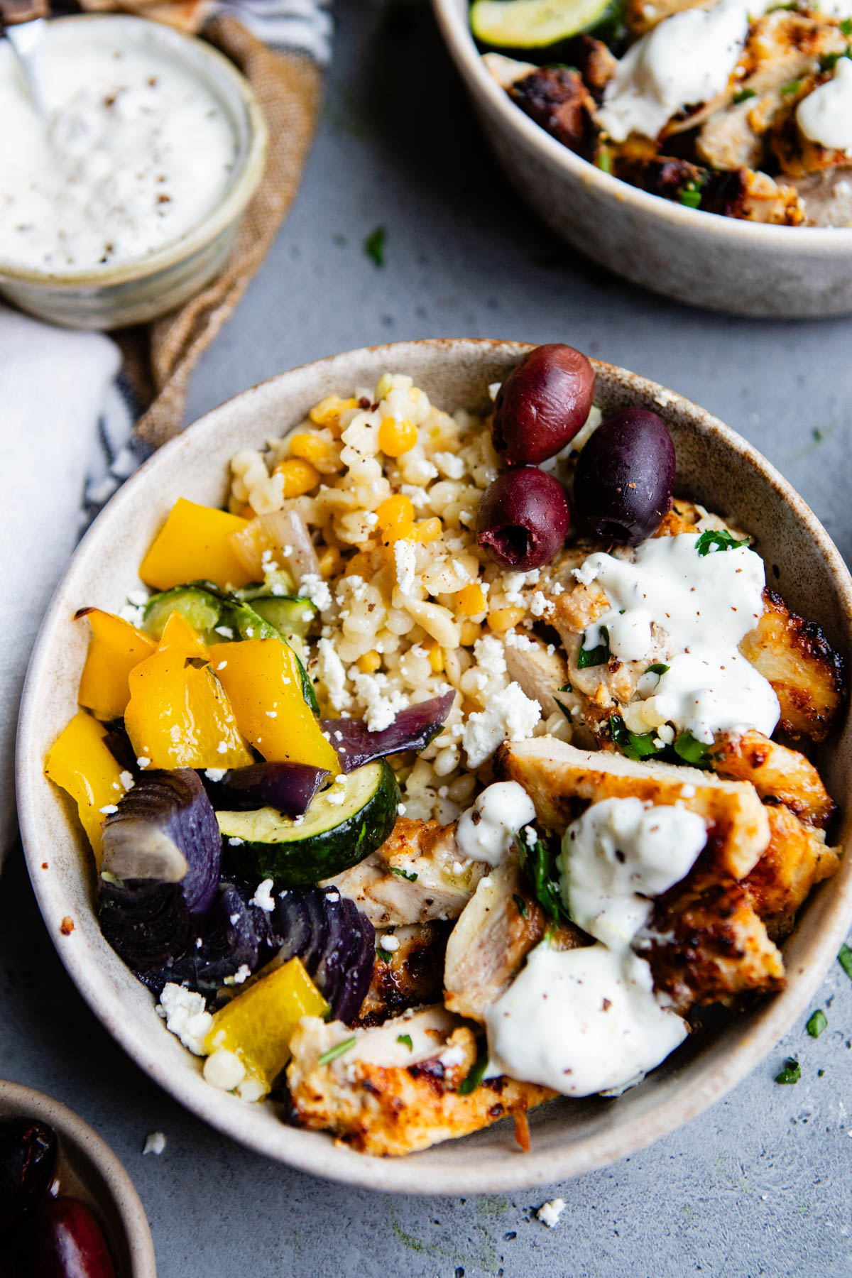 pearl couscous and grilled Mediterranean chicken with roasted vegetables in a ceramic bowl