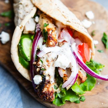 pita wrapped Mediterranean chicken on a wood board