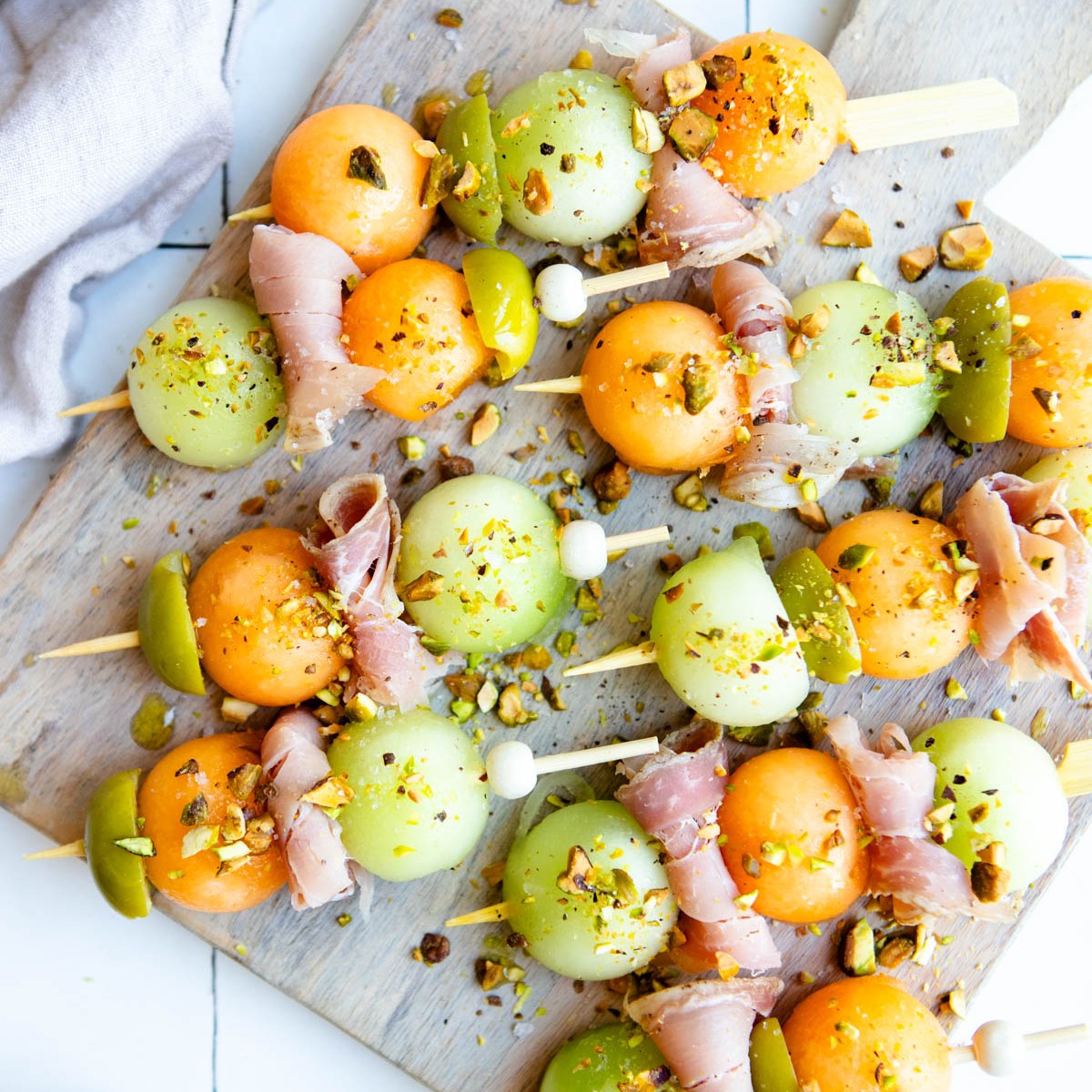 melon balls with thin slices of prosciutto on mini skewers