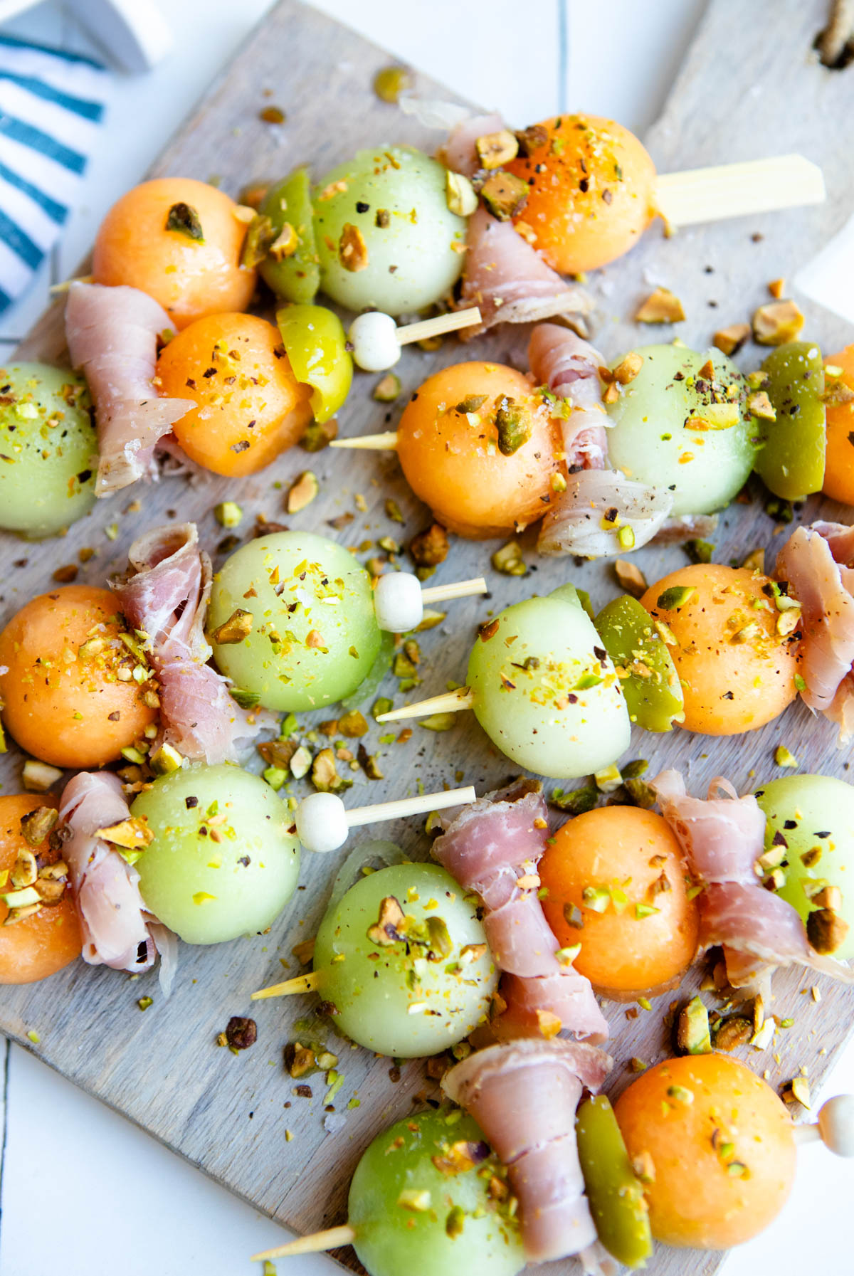 melon and prosciutto skewers with crumbled pistachios sprinkled on top 