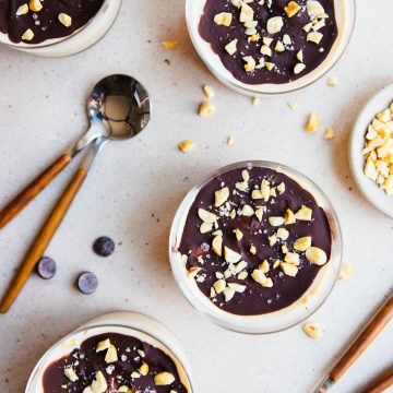 2 spoons next to cups of Greek yogurt dessert garnished with crushed peanuts