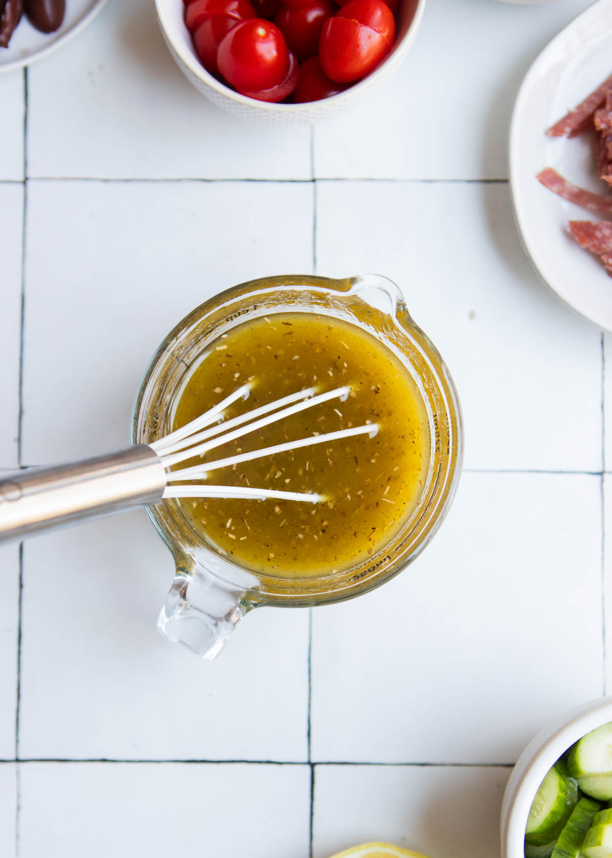 salad dressing recipe for pasta salad in a glass measuring cup with a white whisk 
