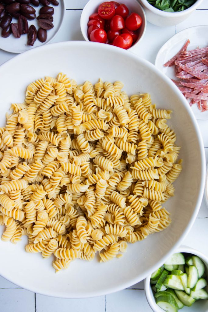 a large white bowl filled with cooked pasta 