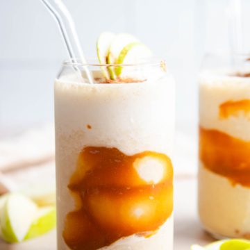 clear glass filled with apple smoothie made with cinnamon and bananas and a caramel swirl