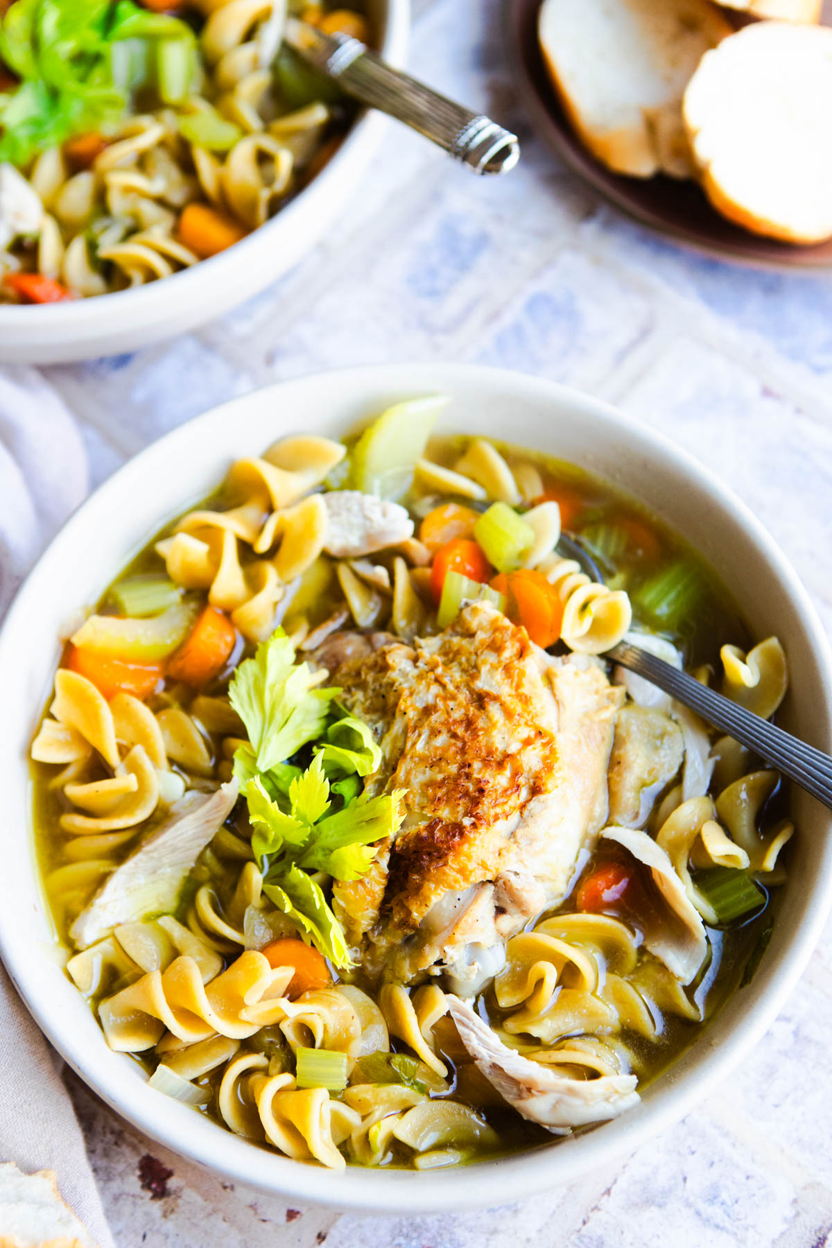 chicken noodle soup homemade and served into large creamy colored bowls