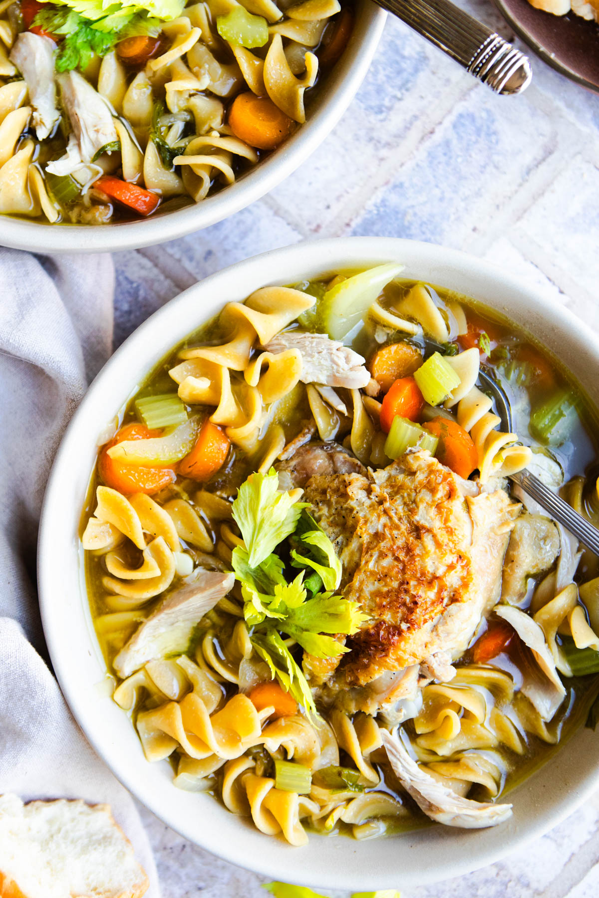 2 soup bowls filled with classic homemade chicken noodle soup