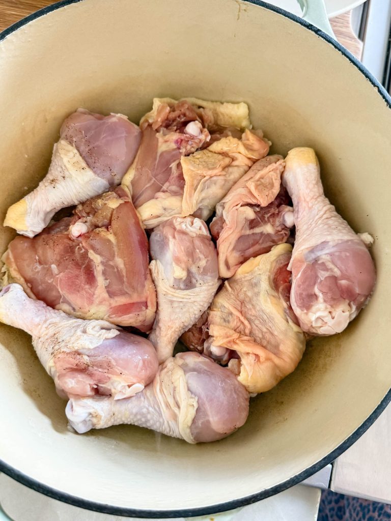 raw chicken thighs and drumsticks in a large Dutch oven