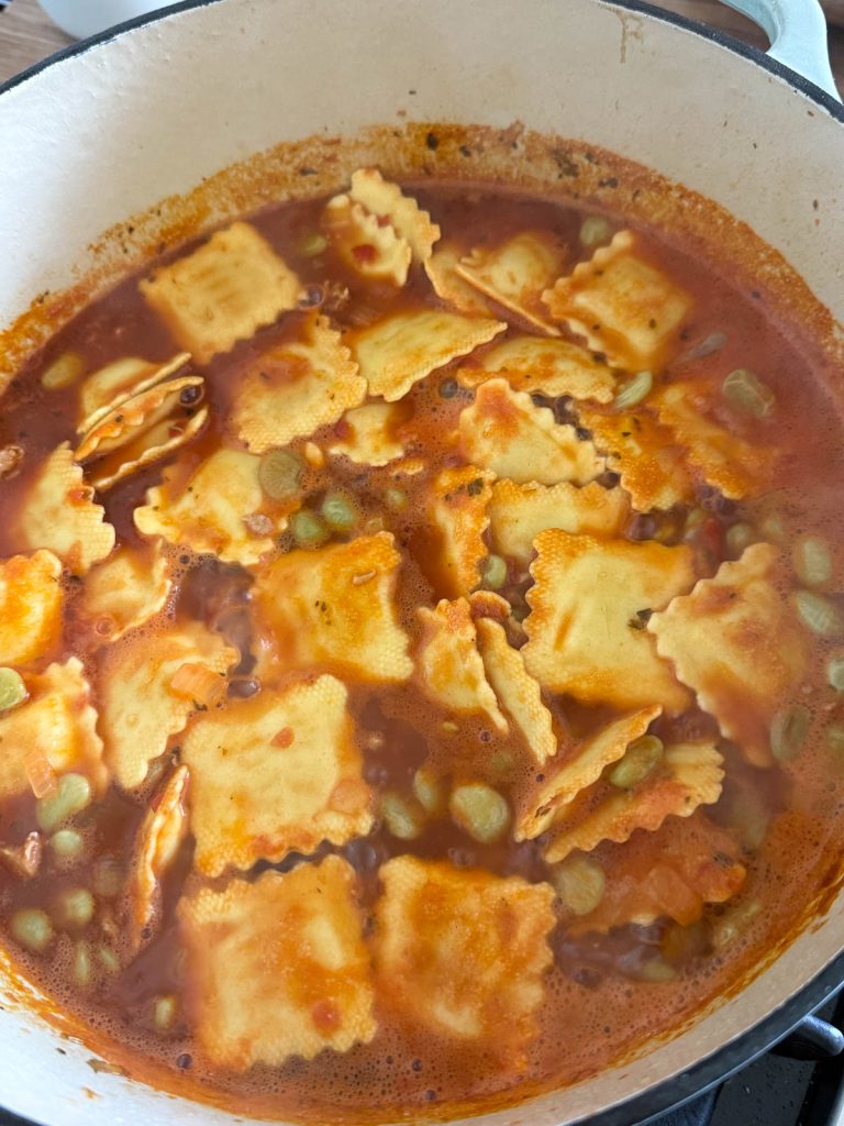 refrigerated cheese raviolis added to a large pot of pasta fagioli soup 