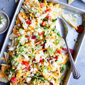 healthy chicken nachos garnished with fresh veggies and green onions