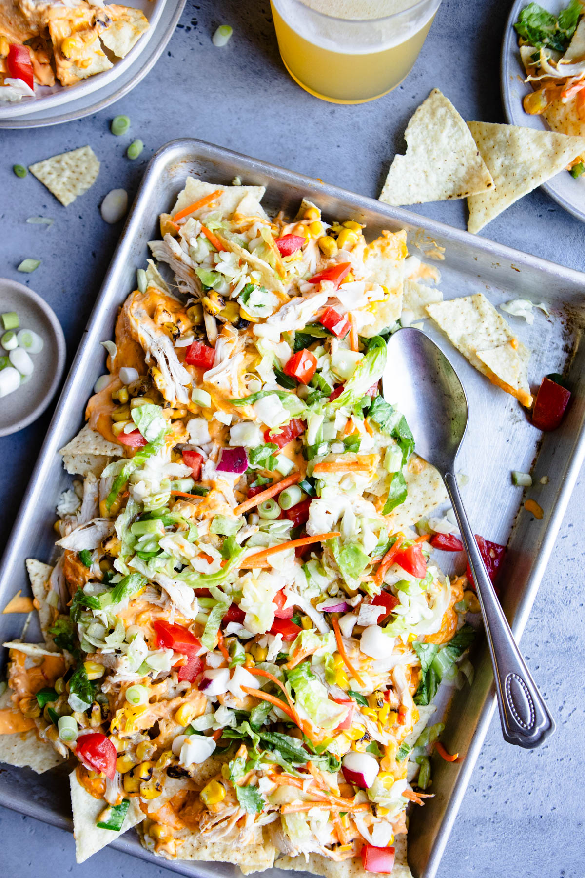 veggie loaded healthy chicken nachos on a sheet pan