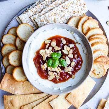 goat cheese and cream cheese savory dip topped with mango chutney and crackers