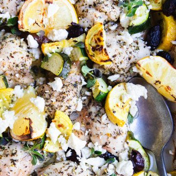 cooked chicken thighs and veggies sprinkled with feta cheese
