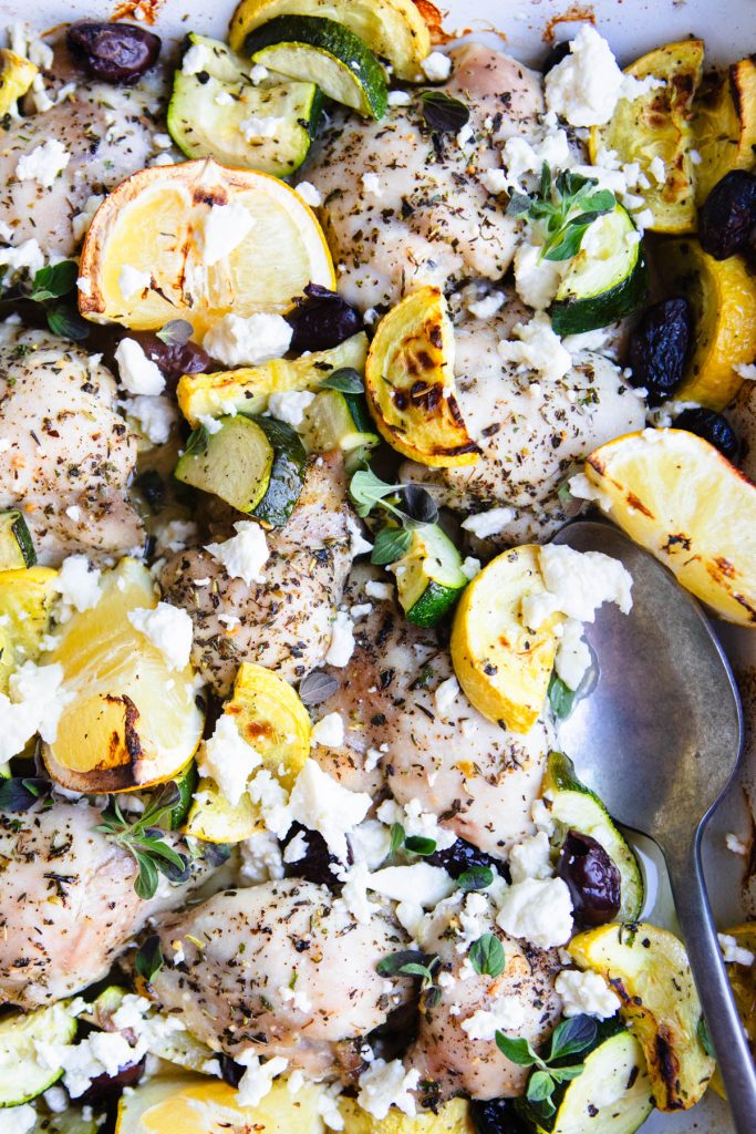 cooked chicken thighs and veggies sprinkled with feta cheese 