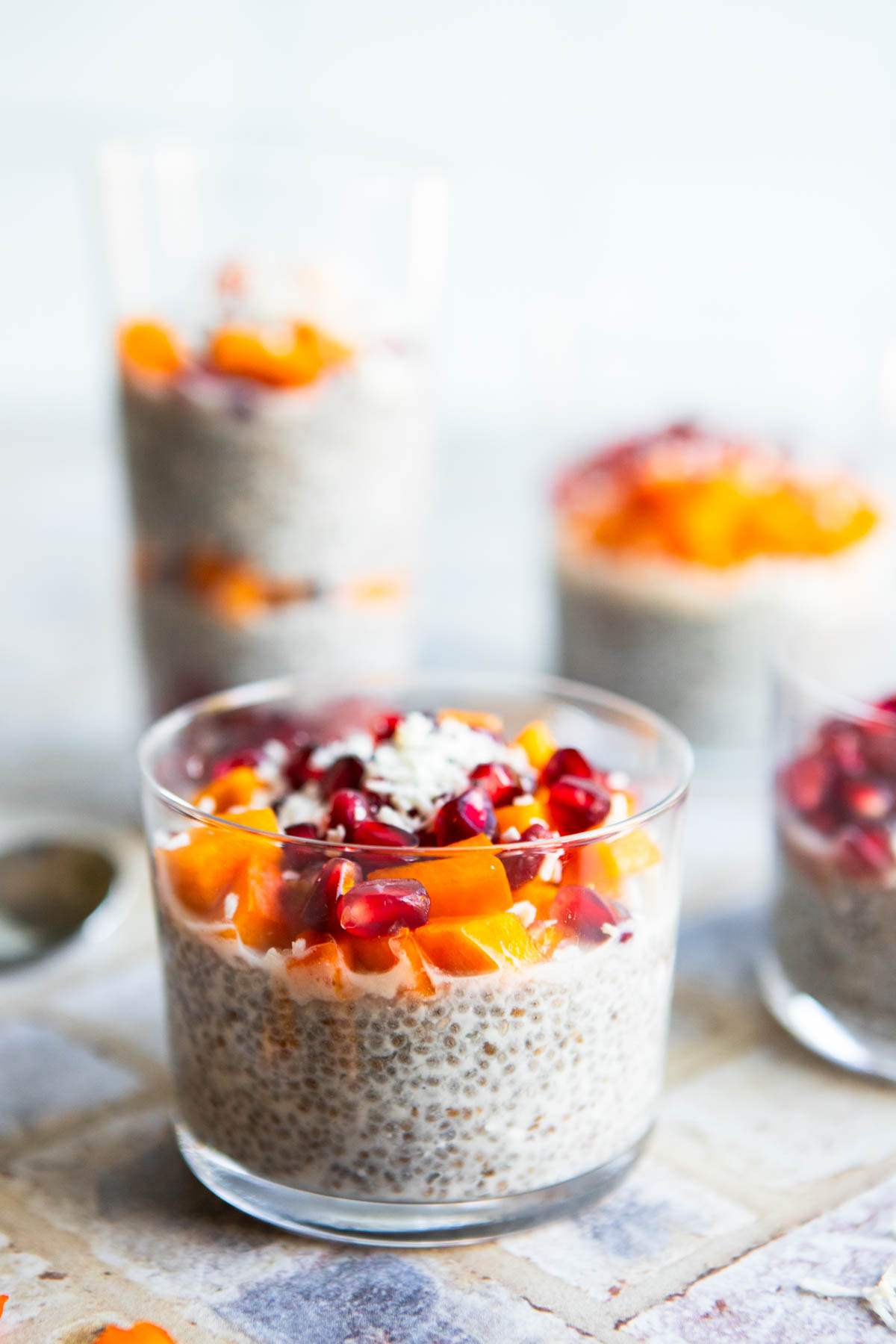 coconut chia seed pudding garnished with pomegranate seeds and persimmons