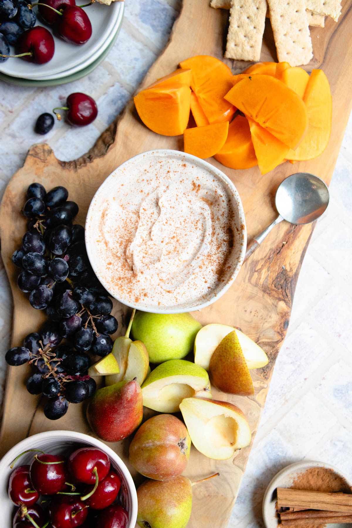 a wooden board filled with fruit and a delicious Greek yogurt fruit dip