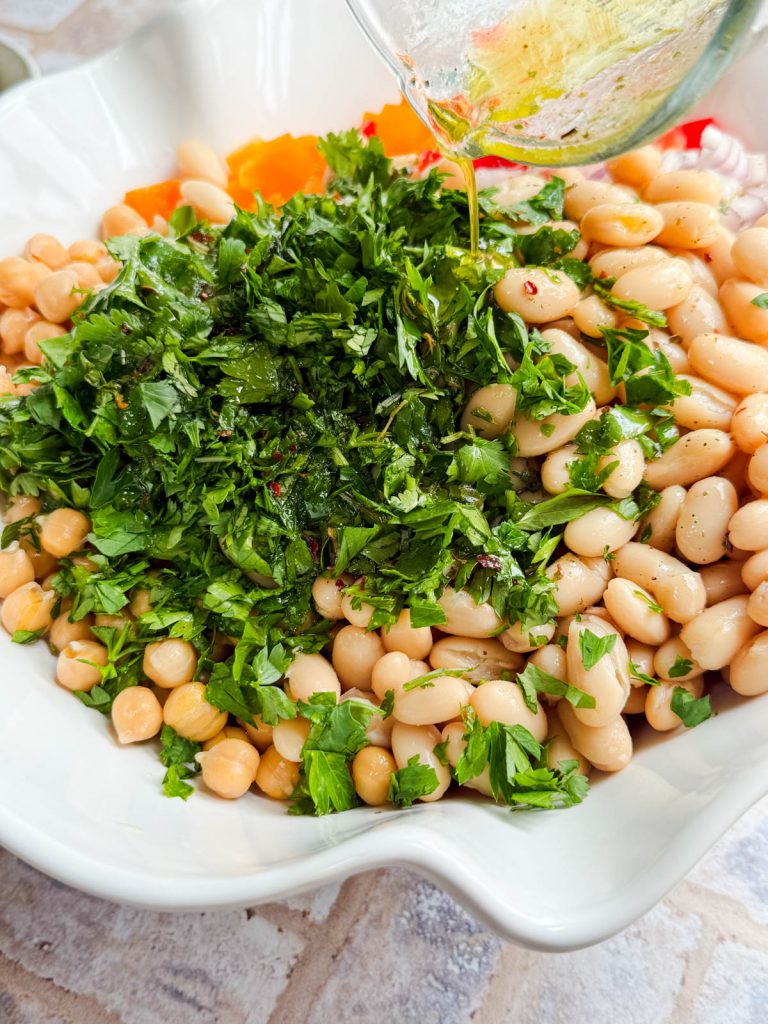 lemon vinaigrette being poured on a bowl of cowboy caviar