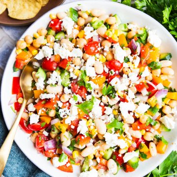 large serving bowl filled with cowboy caviar dip and topped with crumbled feta cheese