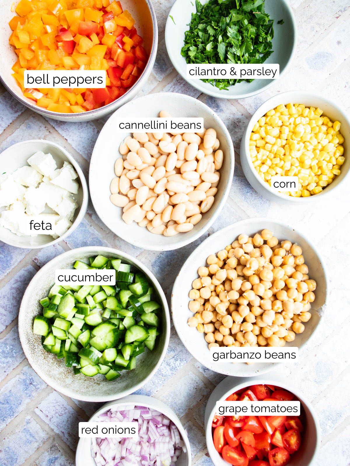 ingredients in small bowls to make cowboy caviar with chickpeas and cannellini beans