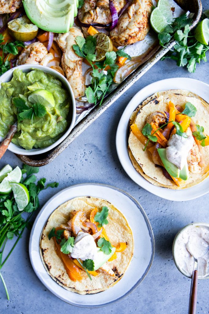 2 chicken fajita tacos garnished with spicy Greek yogurt sauce and avocado