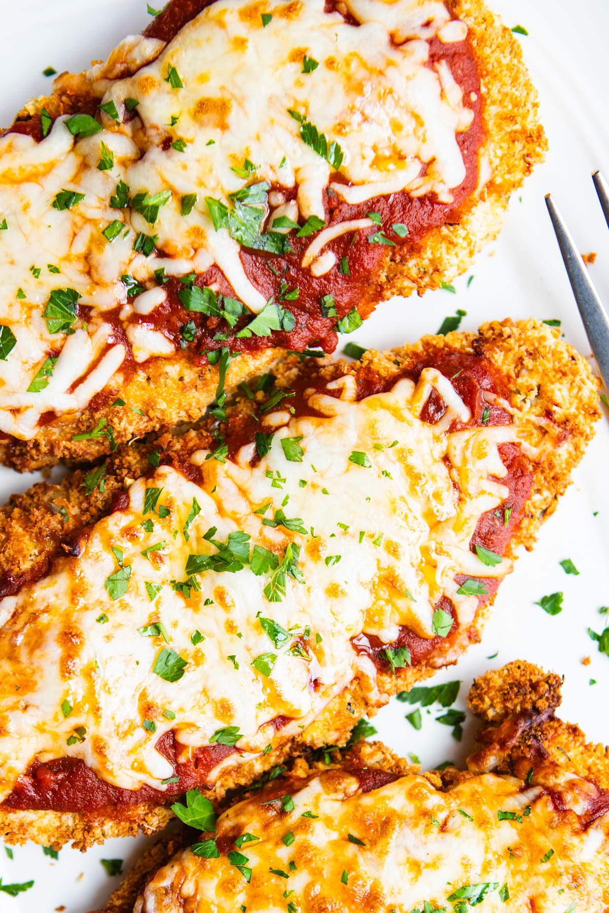 close up photo of breaded chicken parmesan made in the air fryer and topped with lite mozzarella cheese and marinara sauce
