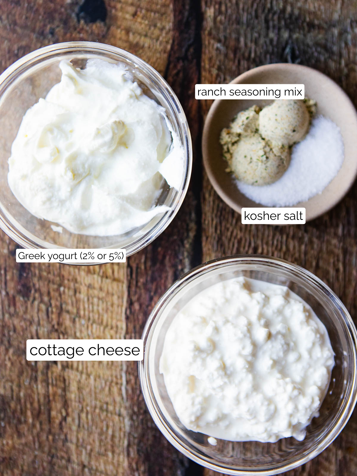 ingredients to make cottage cheese ranch dip in glass bowls on a wood table