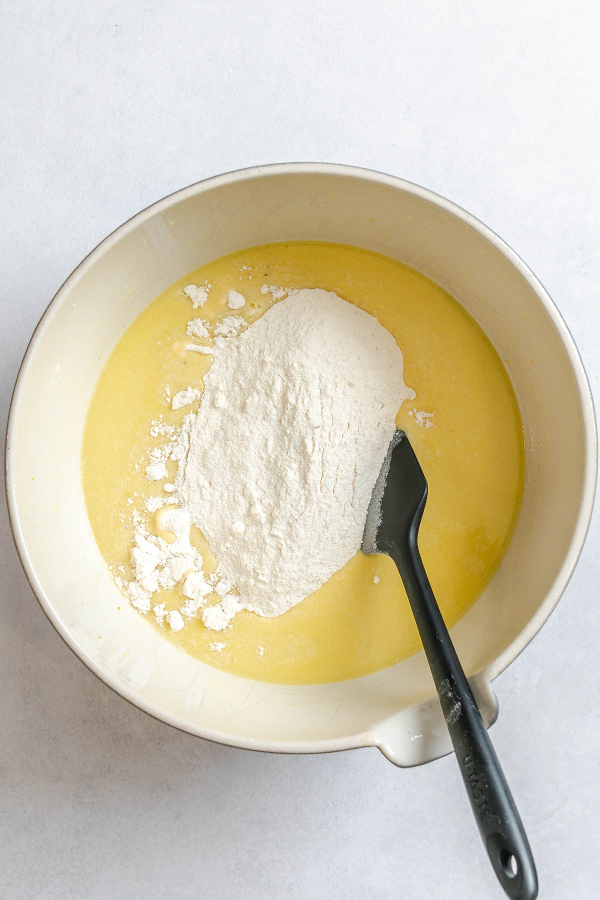 dry ingredients added to wet ingredients to make olive oil cake