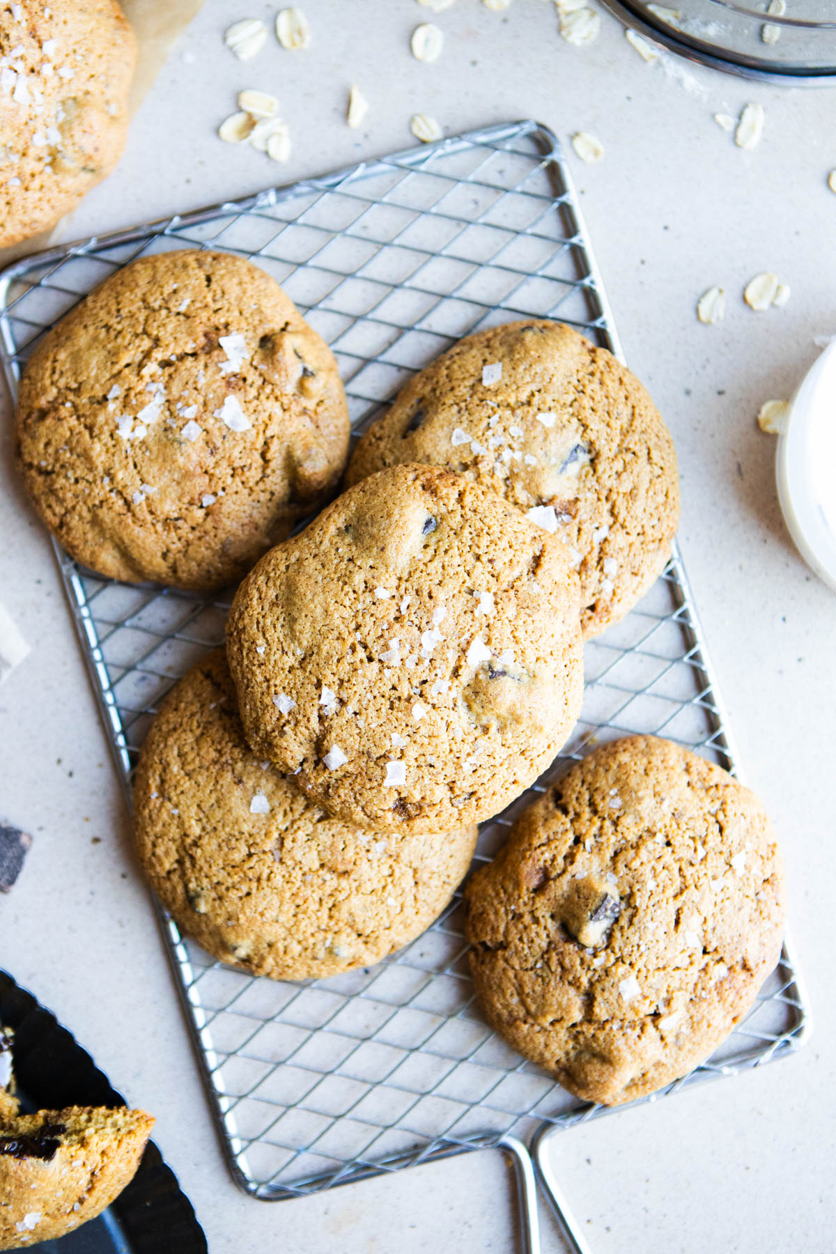 a pile of chocolate chip cookies sprinkled with flay salt laid on a cooling rack