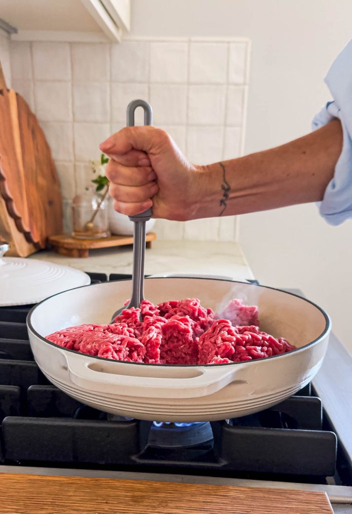 ground beef added to a cast iron pan