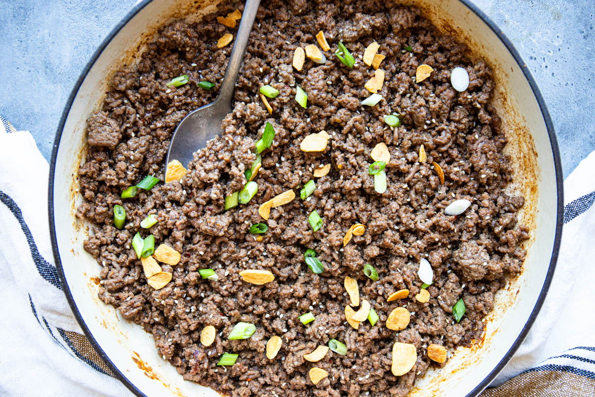 Asian ground beef garnished with crispy garlic and green onions and sesame seeds